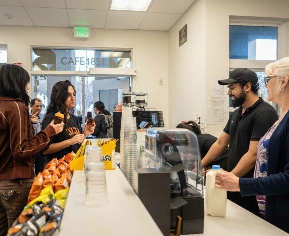 Students making a purchase at the counter in Cafe 1851.